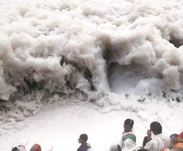 People offering prayers at the Yamuna River in India which is frothing from industrial waste