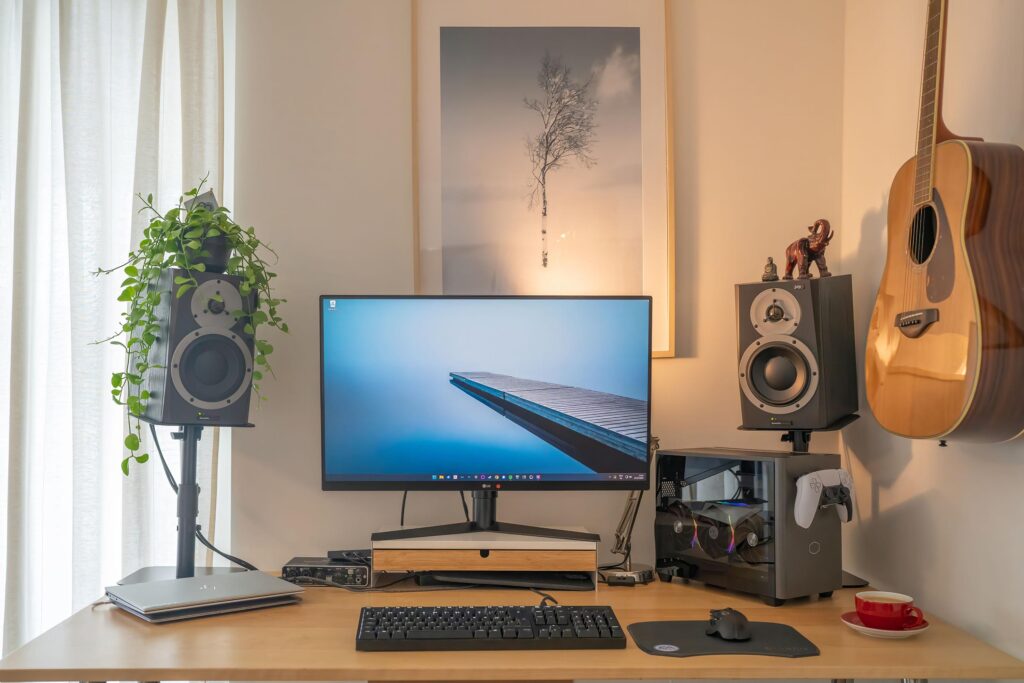 Have follow you guys' advice: Moved the computer away from under the guitar and got some actual monitor stands. Thanks for the input!