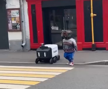 Cyberpunk is here: a robot in clothes moved a delivery bot across the road