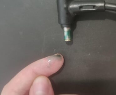 What is this blue liquid comming out of laptop charging port? Also feels like there is sand in the port... I let the laptop plugged in over night.