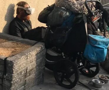 A homeless man wearing a VR headset