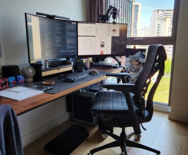 Expanding my workspace with dual 32" displays and hiding all my laptops behind the monitor for more desk space