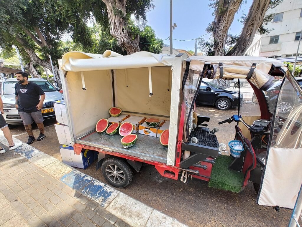 Genetically enhanced seedless watermelons being sold out of an electric tuktuk