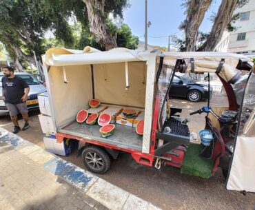 Genetically enhanced seedless watermelons being sold out of an electric tuktuk