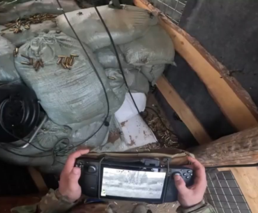 ukraine soldier using a steam deck to operate an lmg