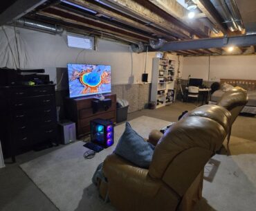 Rigged together station made from junk.  All the speaker mounts are made from junk I had laying around.  A bunch of used dressers that my wife refused to let go made good entertainment stands.  The arm rest makes a great mouse pad though.