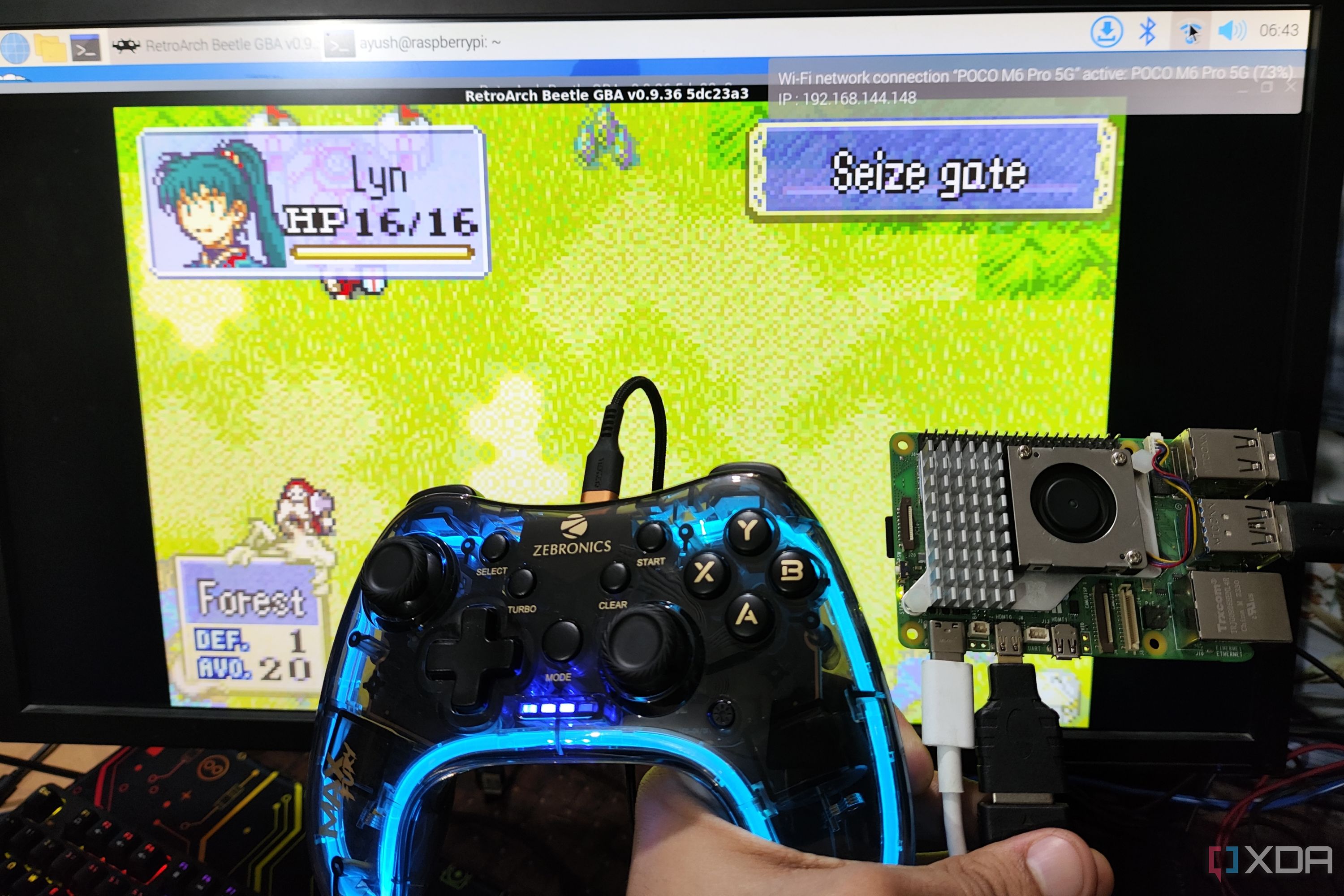 A Raspberry Pi 5 and a controller held in front of a PC screen