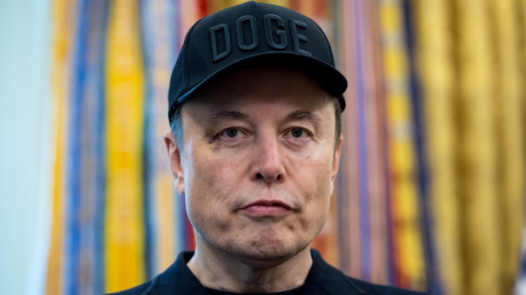 Elon Musk, chief executive officer of Tesla Inc., wears a "DOGE" hat during a news conference in the Oval Office of the White House in Washington, DC, US, on Friday, May 30, 2025. The event gives an opportunity for the president and his largest campaign benefactor to dispel any notion of an acrimonious divorce. Photographer: Francis Chung/Politico/Bloomberg via Getty Images