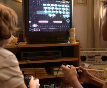 Two boys playing retro video games on a CRT TV