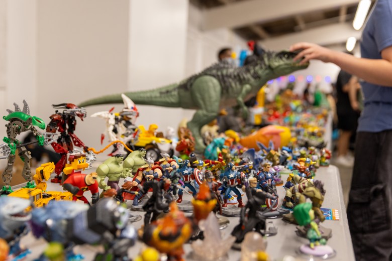 A colorful assortment of action figures and collectibles, including superheroes and dinosaurs, displayed by Central Valley Collecting Toys at the Gamer Festival.