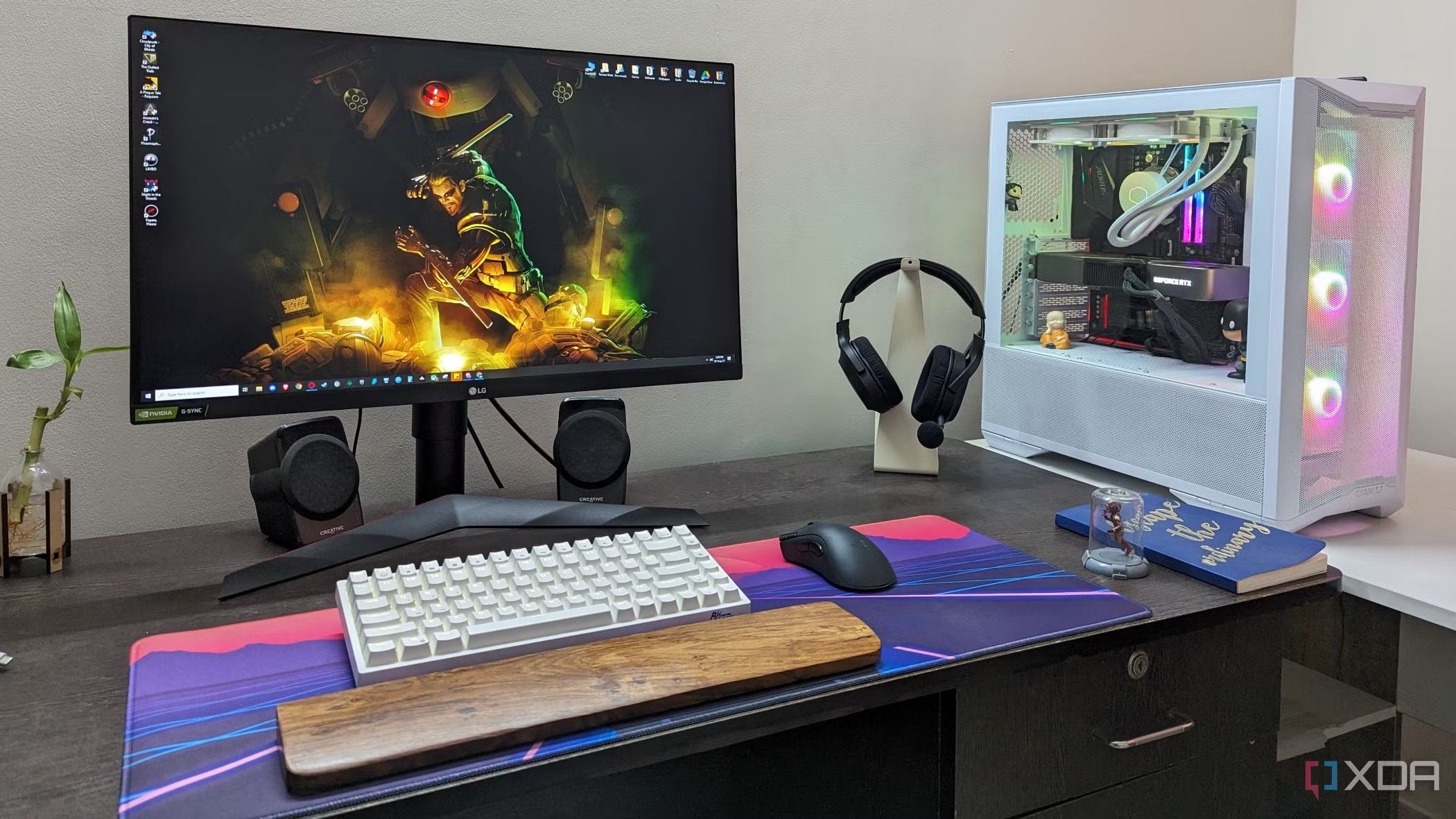 A desktop PC setup with a large mouse pad, keyboard, mouse and headphone on the desk