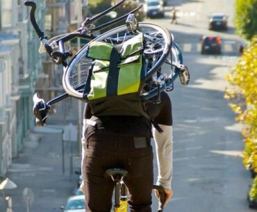 Riding a bike with a bike in the bag.