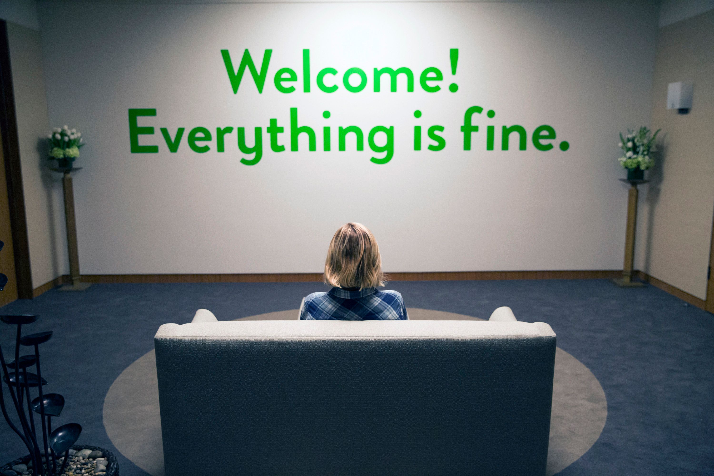 A still image from the NBC series 'The Good Place' with a wall that says "Welcome! Everything is fine."