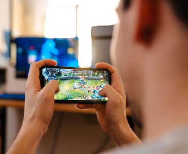 A person plays a multiplayer online battle arena game on a smartphone. (Adobe Stock Photo)