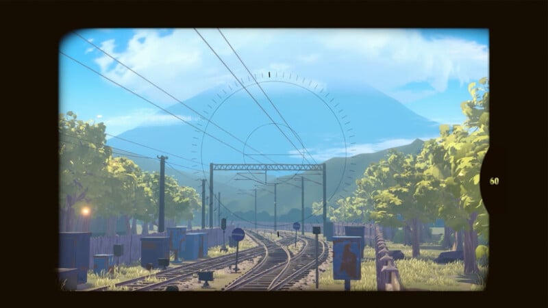 A scenic view of railway tracks curving through a lush, green landscape, framed as if seen through a camera viewfinder, with mountains and a bright blue sky in the background.