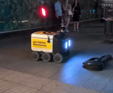 Wonder if the robot tipped the musician... or at least shared some of the food it was delivering