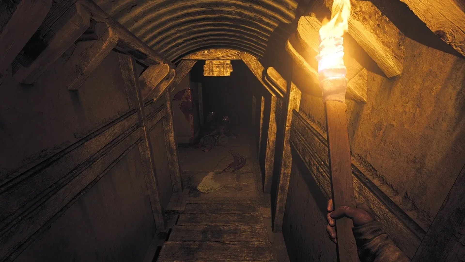 A screenshot of Henri walking down stairs into a dark corridor in Amnesia: The Bunker