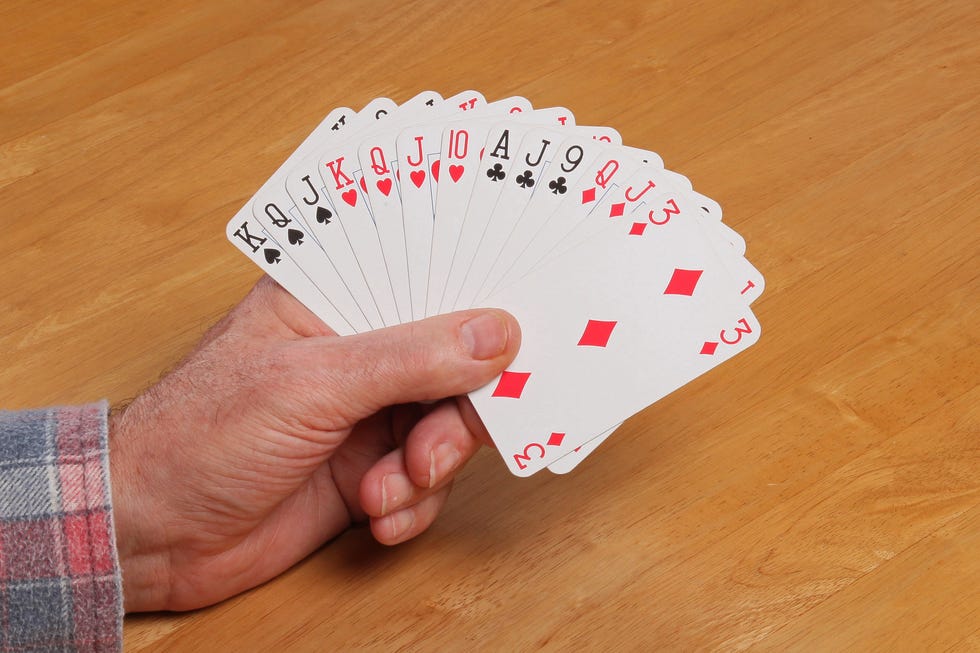 a contract bridge hand held by mans hand, with 13 cards a contract bridge hand held by mans hand, with 13 cards
