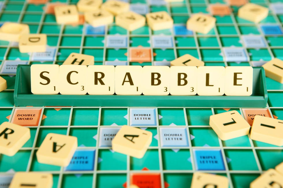 colorful green scrabble game board with tiles on tile holder spelling out scrabble and other tiles tossed on board colorful green scrabble game board with tiles on tile holder spelling out scrabble and other tiles tossed on board