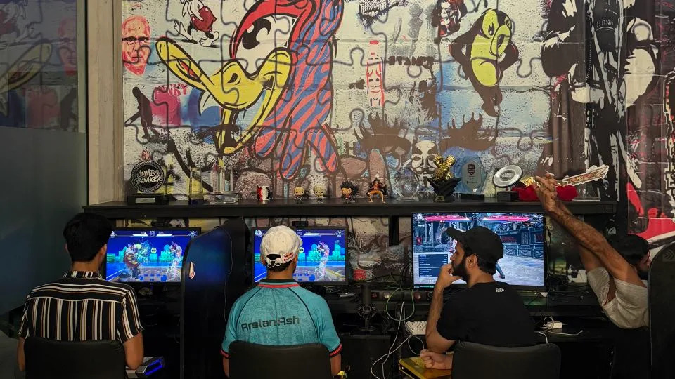 Arsalan “Ash” Siddique, center, practices at the Maniax arcade. - Javed Iqbal/CNN