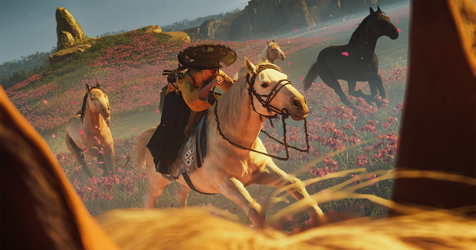 Ghost of Yōtei’s Photo Mode Features a Physics-Defying 12-300mm f/1.2 Lens A warrior in traditional Japanese attire rides a white horse through a vibrant field of pink flowers, surrounded by other galloping horses under a bright sky.