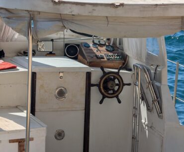 Old wooden boat with wood dashboard and analog instruments upgraded with solar panels and advanced radar and sonar