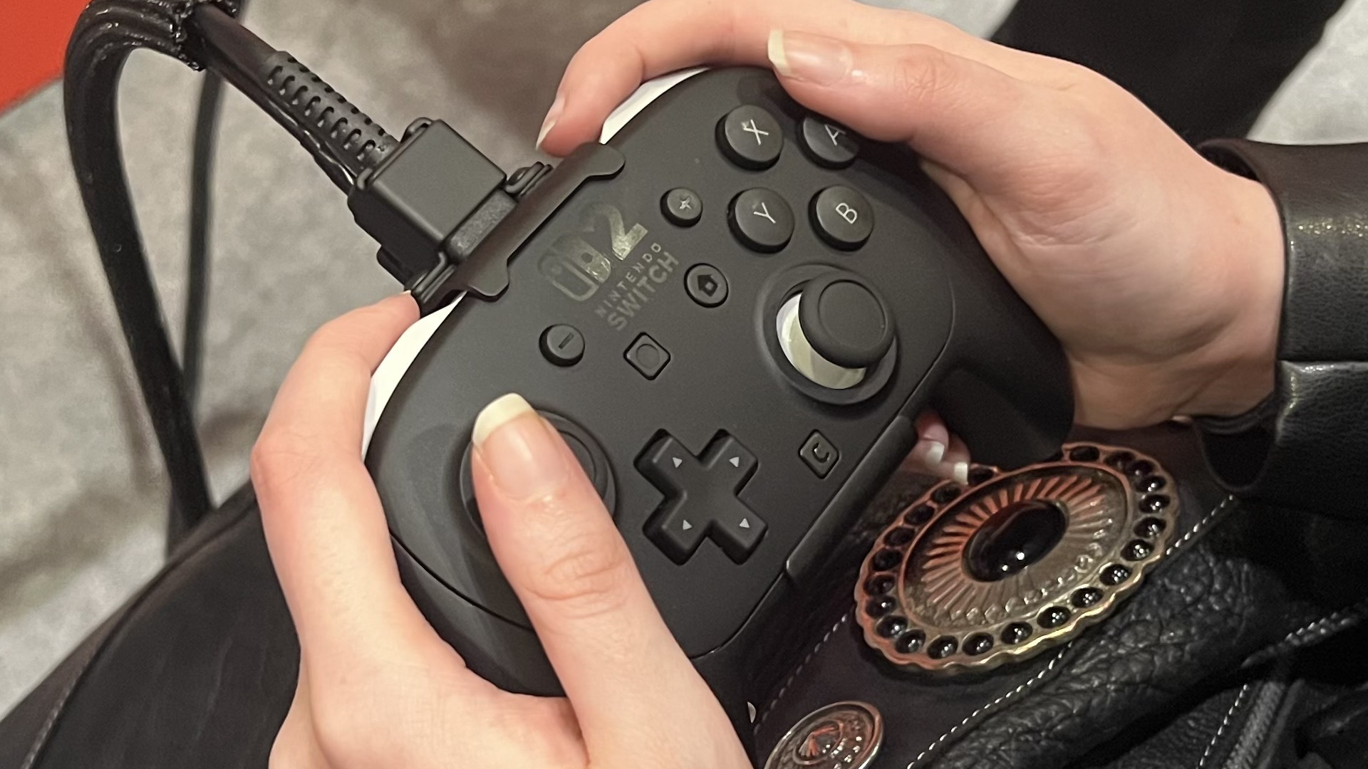 A pair of hands holding the Switch 2 Pro Controller