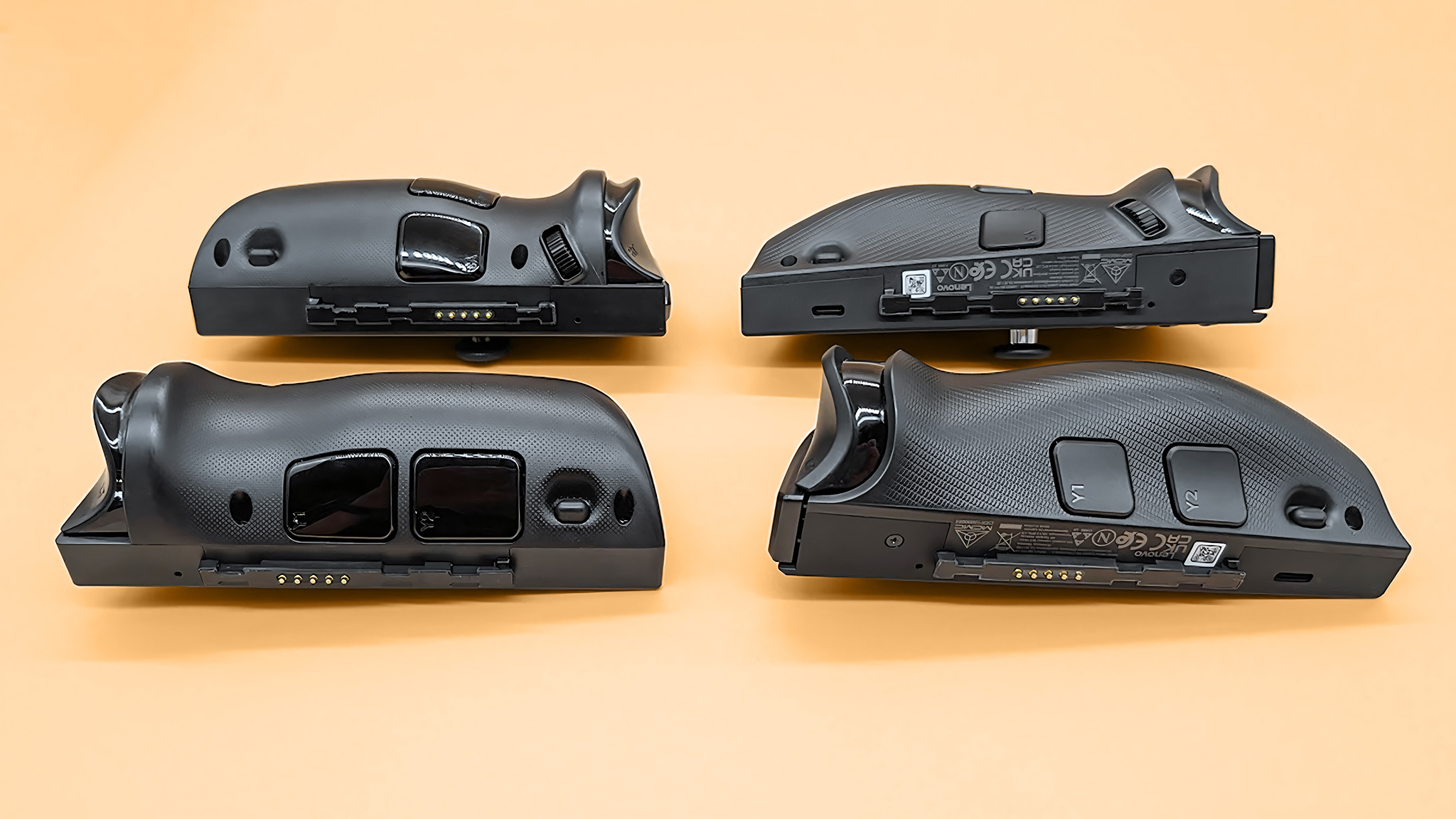 The Lenovo Legion Go 2 and original Legion Go controllers lying down so that their connection pins are visible. 