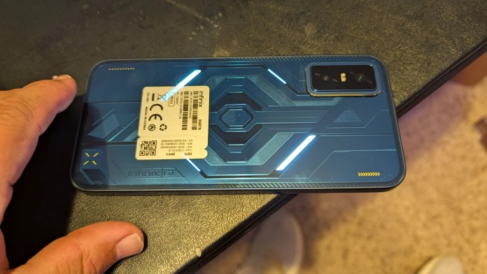 Close-up view of the back of the Infinix GT 30 smartphone, showcasing its blue, cyberpunk-inspired design, geometric patterns, and programmable LED lighting.