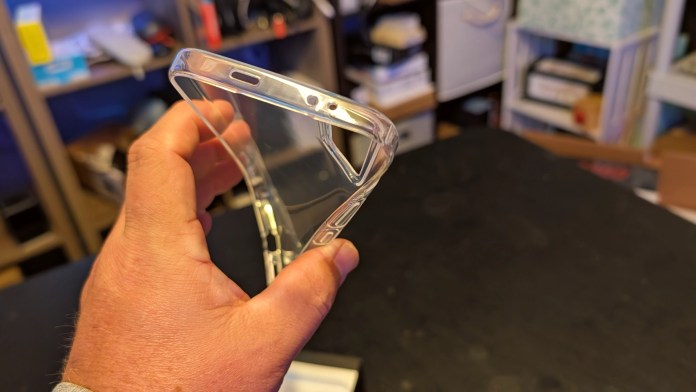 A person holding a clear phone case with an angled view showing the cutouts for buttons and ports.