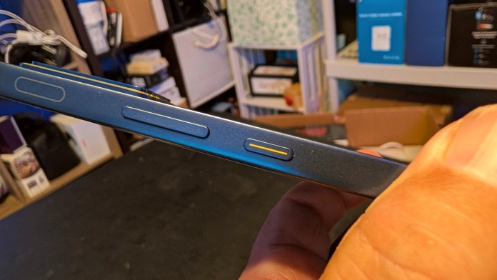 Close-up of the side of the Infinix GT 30 smartphone, highlighting the power and volume buttons, with the distinctive red-striped power button visible.