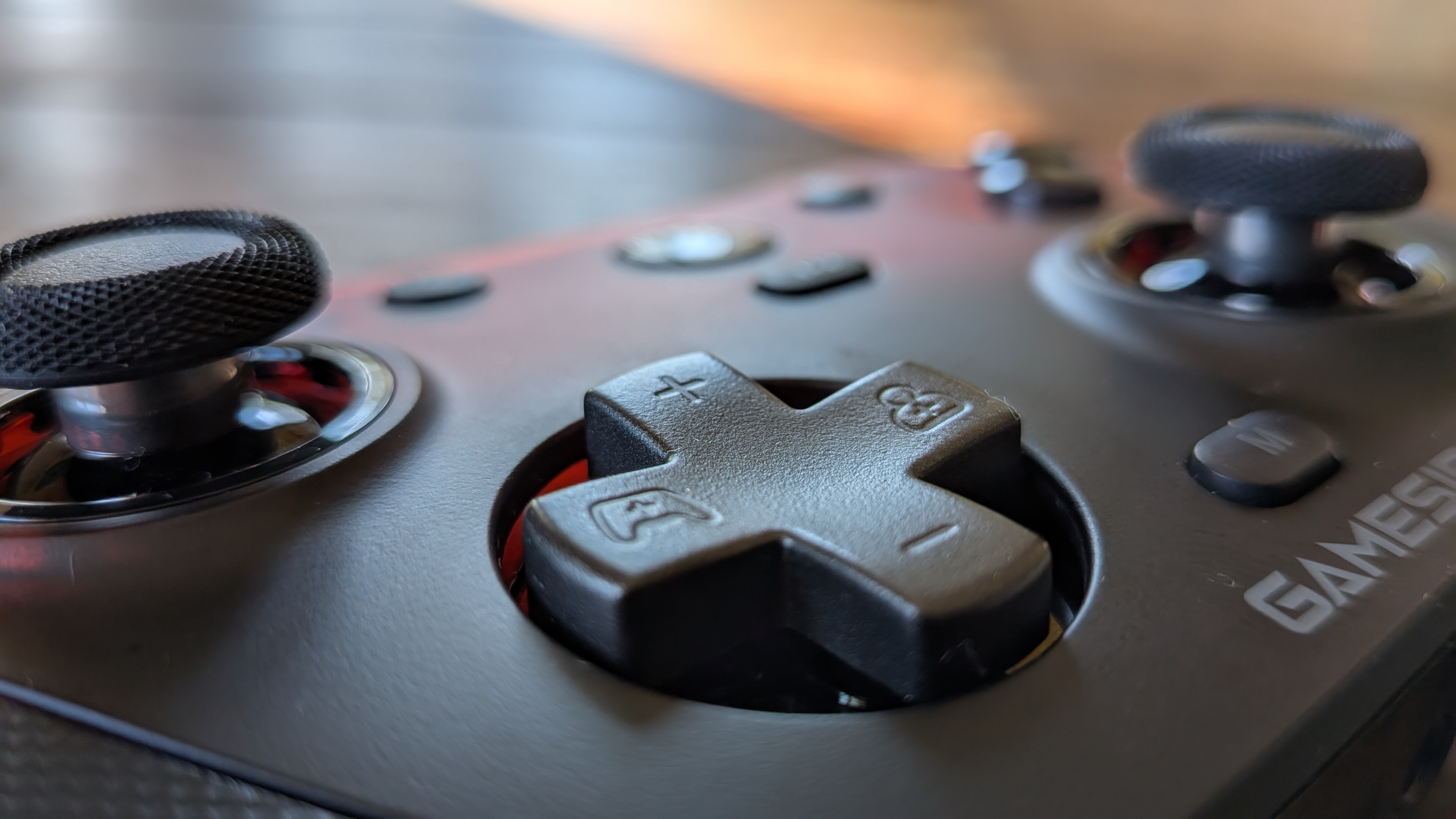 The GameSir G7 Pro's directional pad in the foreground, with its two analog sticks in the background