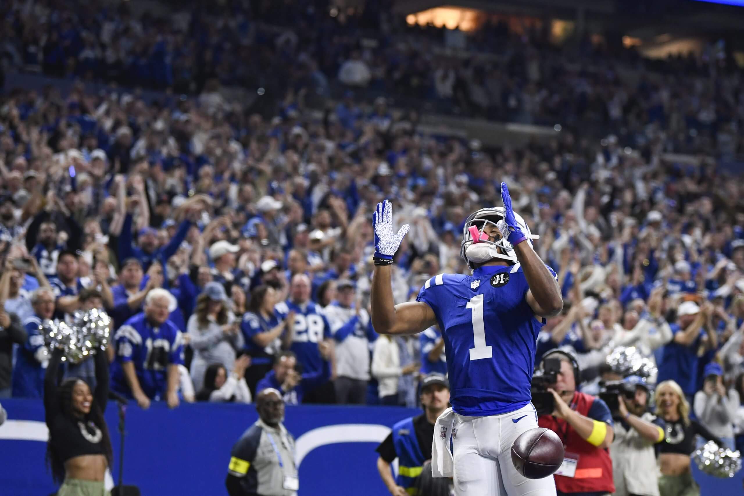 Josh Downs, in a blue uniform, raises his arms and looks up.