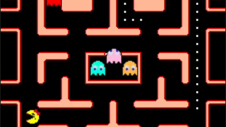 Ms. Pac-Man is in the bottom left corner of the screen as three ghosts sit in their holding cell in 
