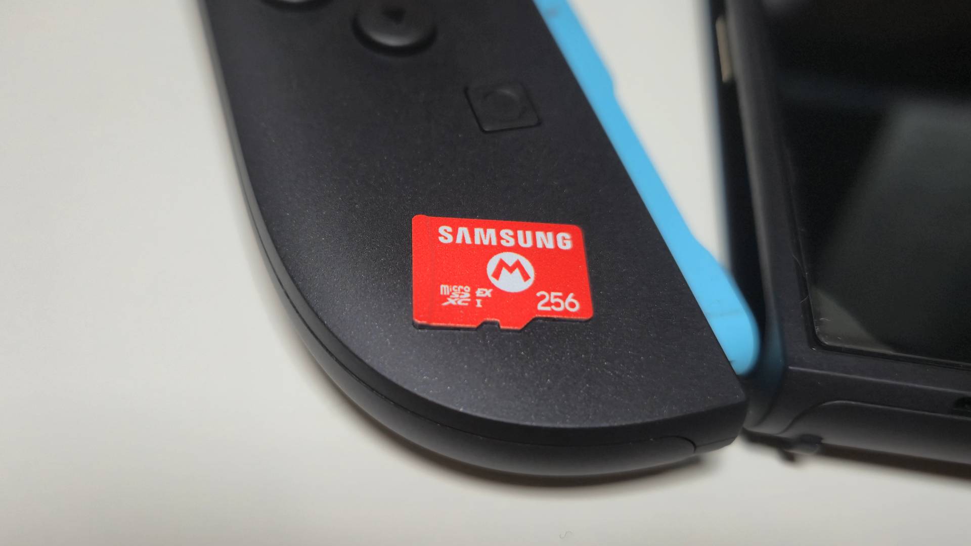 Photo of the Samsung 256GB microSD Express Card sitting on the left Joy-Con 2 controller of a Nintendo Switch 2.