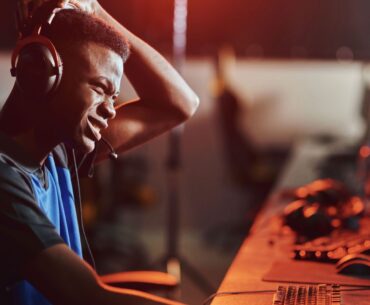 Confused looking PC gamer sitting at a gaming desktop PC