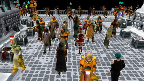 Jagex An area of the game crowded with players mostly wearing orange armour. There are dozens of players on-screen. Some characters are holding weapons like swords, and it is all set against a night scene with grey bricks and snow. In general, the graphics look like something that would have been cutting edge 20 years ago.
