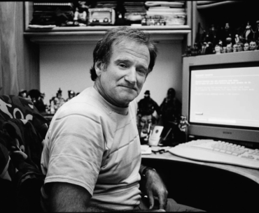 Robin Williams showing off his PC setup, with a Max Payne mouse pad.