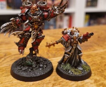 Two fully painted Warhammer Kill Team miniatures on a wooden table