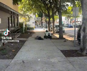 Delivery robot named “Akira” navigates around homeless man sleeping on the sidewalk.