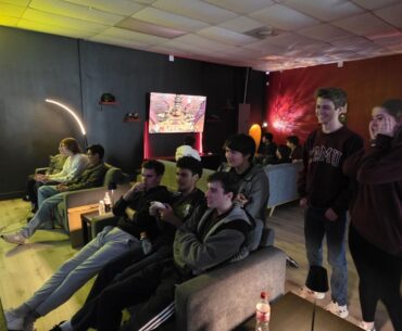people sit in a dim room playing video games