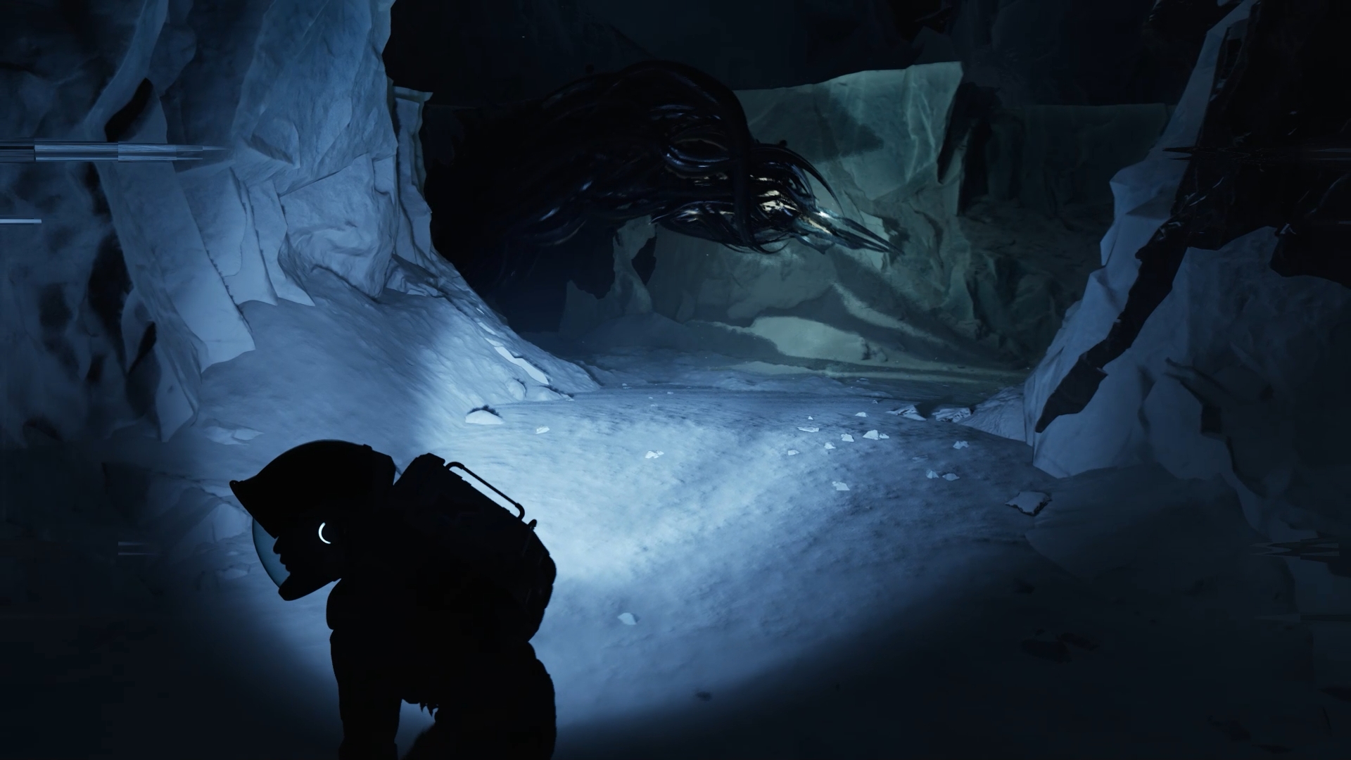 An astronaut explores a dark, icy cave with a shadowy creature in 'Aphelion.'