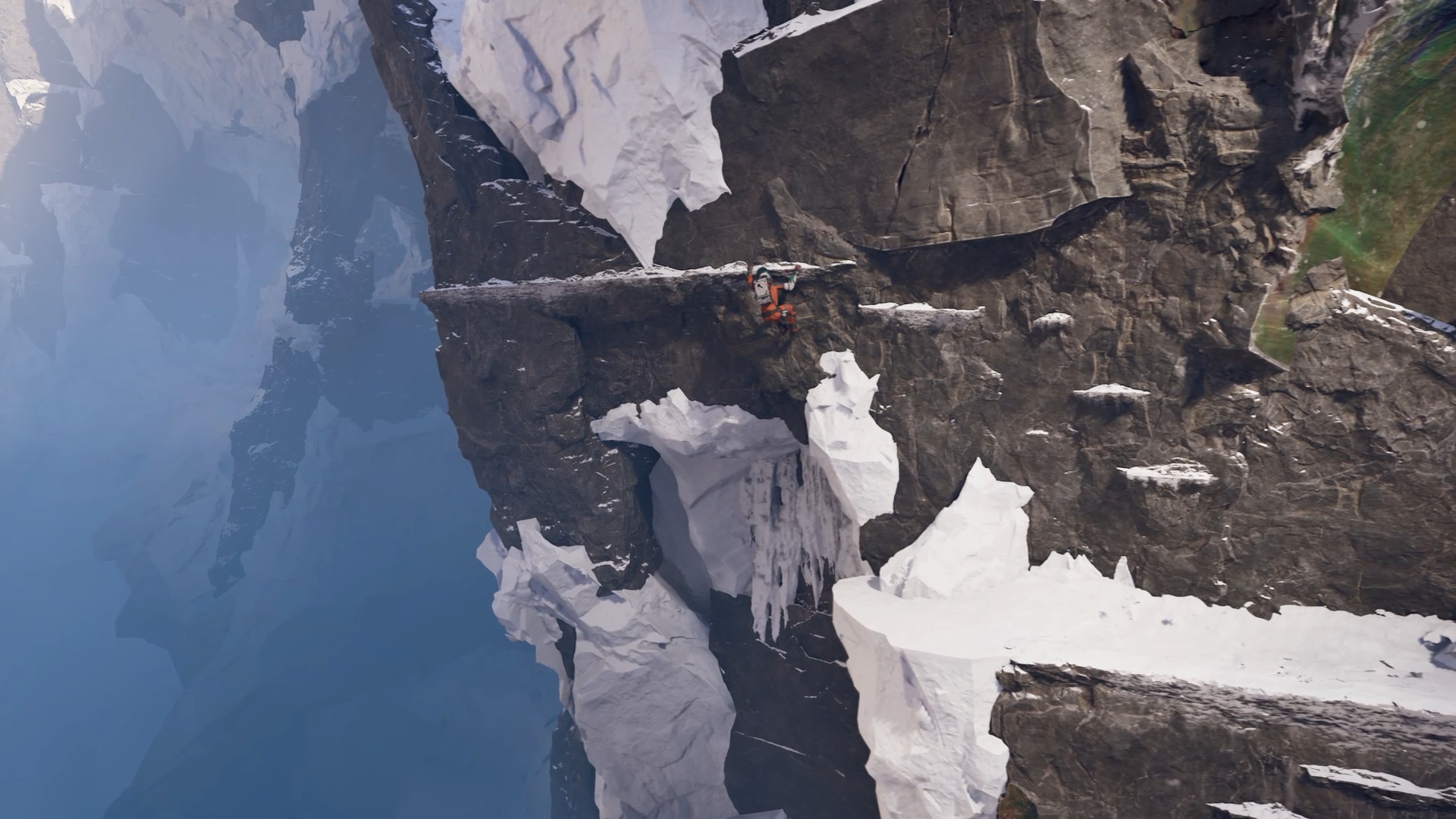 A character from Aphelion in climbing gear hangs from a snowy ledge on a steep mountain in a video game, showcasing a dramatic and icy