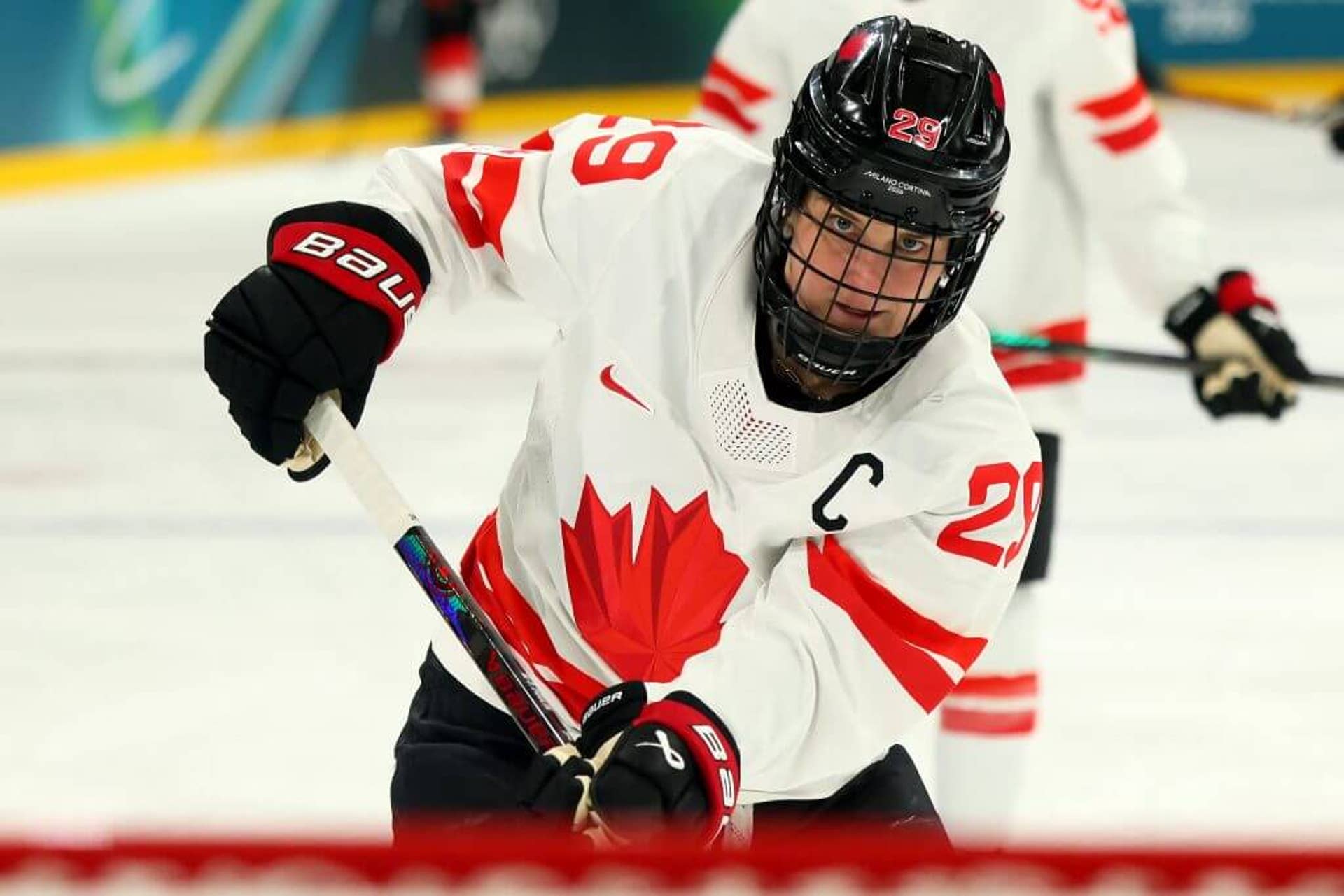 Marie-Philip Poulin, wearing a white Team Canada jersey, holds her stick during an Olympic hockey game in Milan