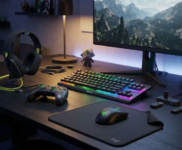 Assorted gaming products arranged on a deck with a gaming monitor.