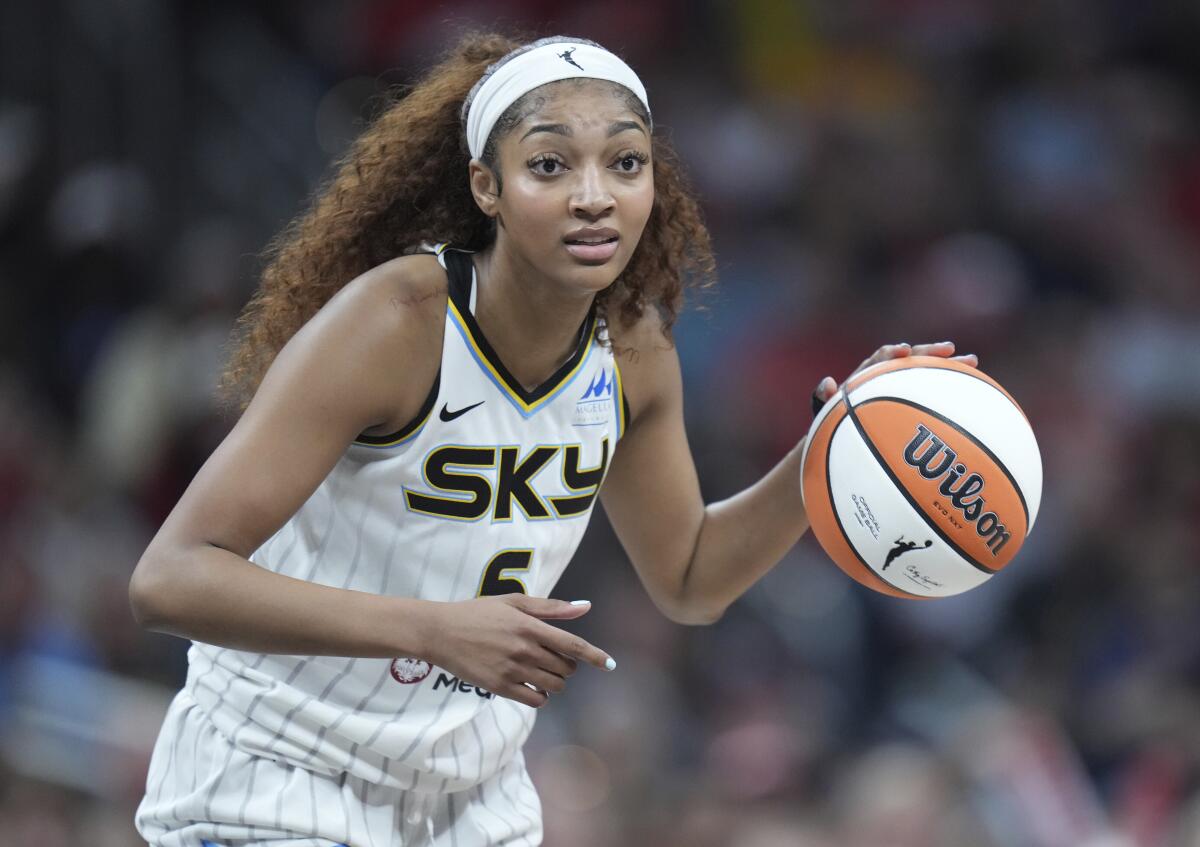 Chicago Sky forward Angel Reese looks downcourt while dribbling the ball. She wears a white headband