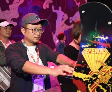Gaming industry personnel Fengliang Shen plays 'Defender' during the E3 Video Game Convention at the Los Angeles Convention Center on June 11, 2019 in Los Angeles, California.