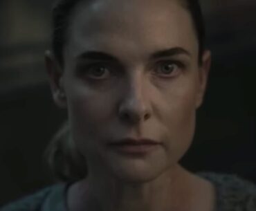 close up of woman with hair pulled back in a ponytail looking resolved