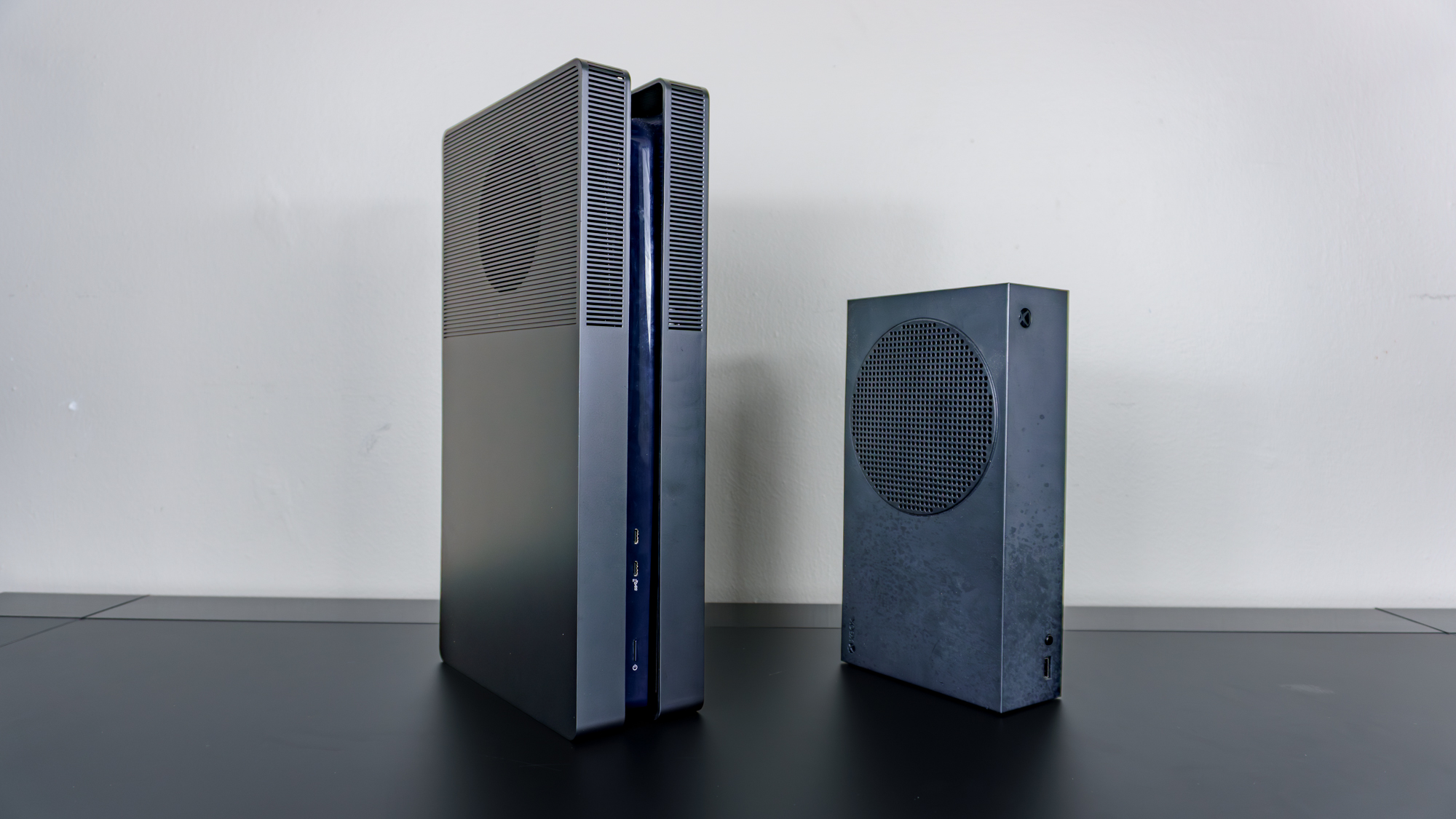A PS5 Pro with BoxPlates console covers installed next to an Xbox Series S on a desk