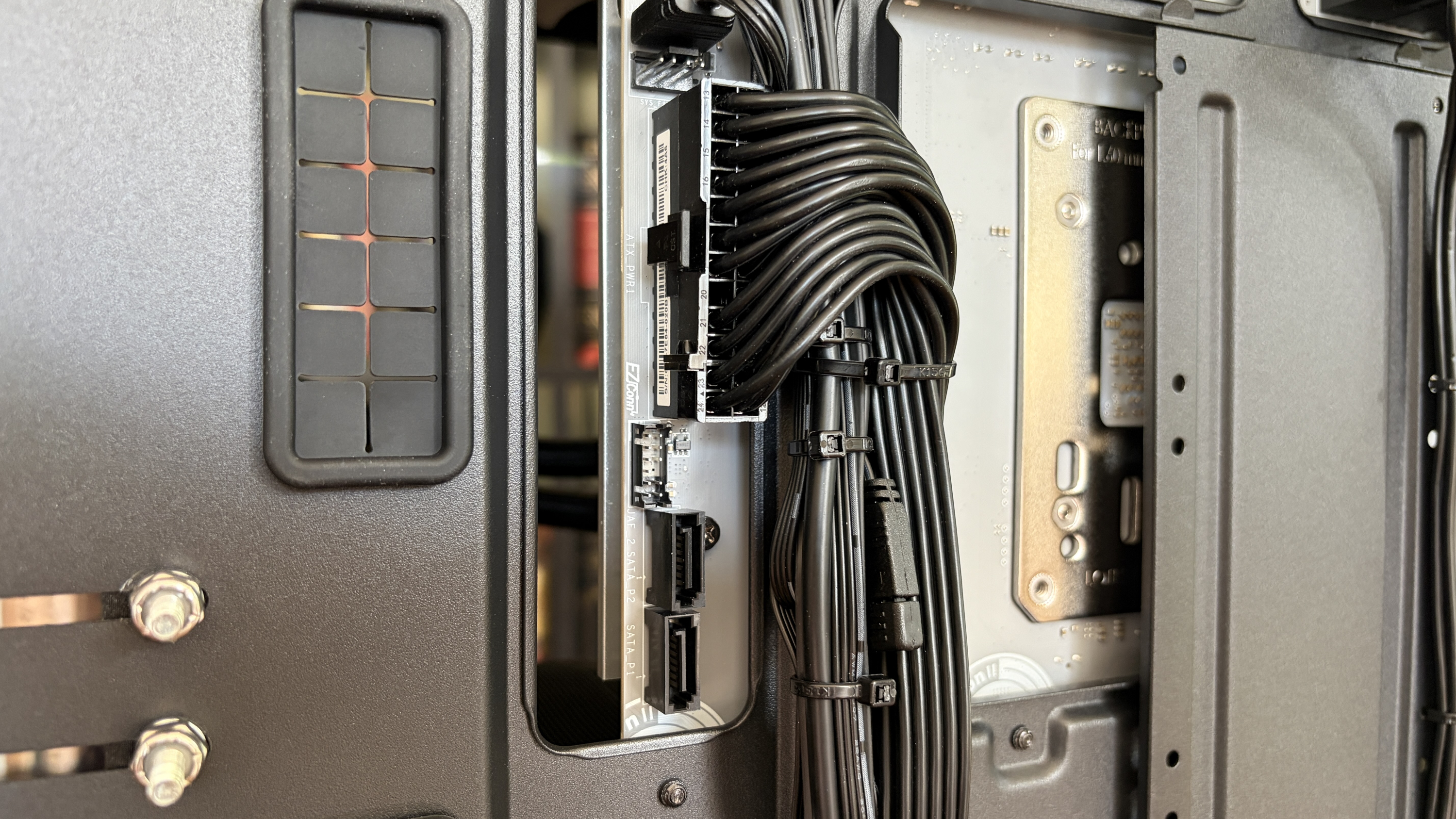 Close-up of a sleek MG-1 MK.II computer case interior showcasing organized black cables connected to a hub. The tone is technical and tidy, emphasizing precision.